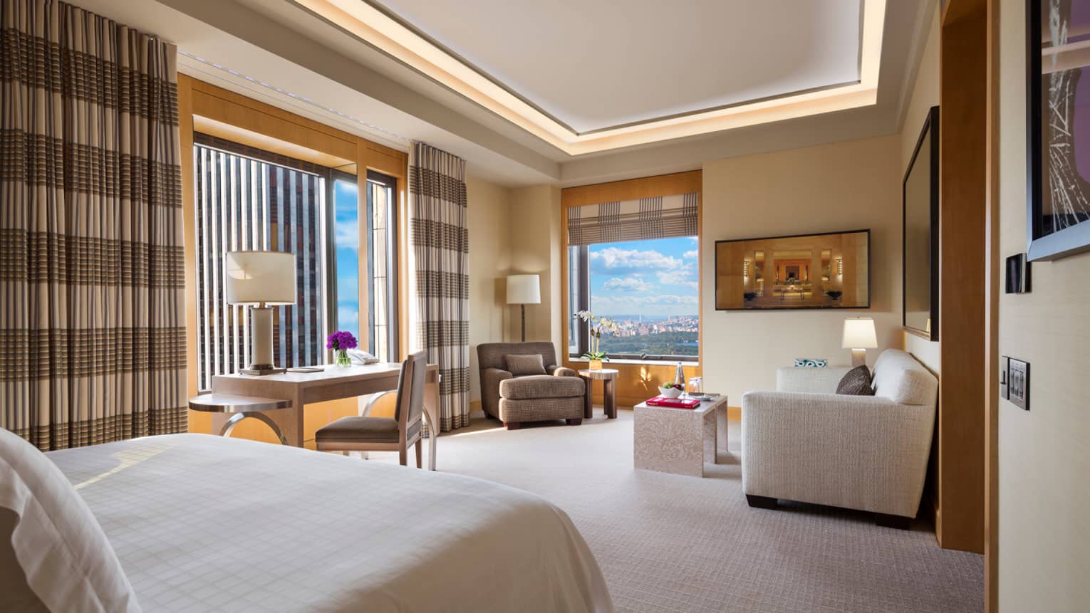 Central Park Junior Suite end of bed, long striped curtains on windows, sofa, chair