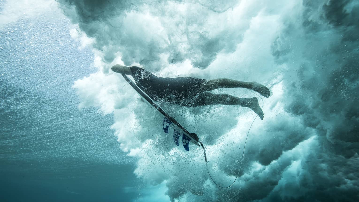 Angled shot of Tropicsurf pro breaking the surface of a wave 