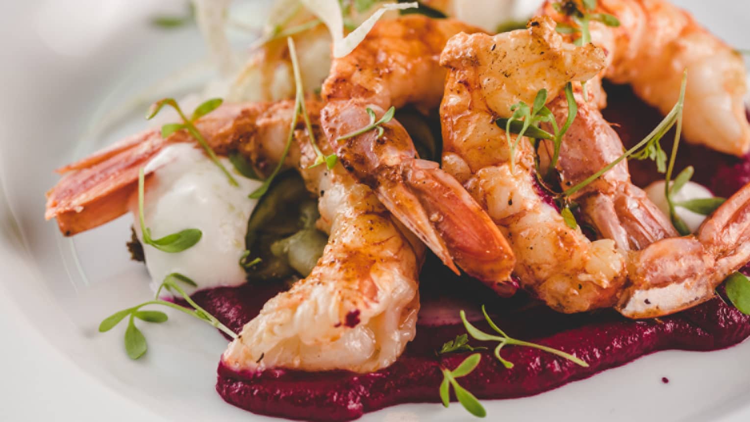 Large barbecued shrimp on bed of vegetables