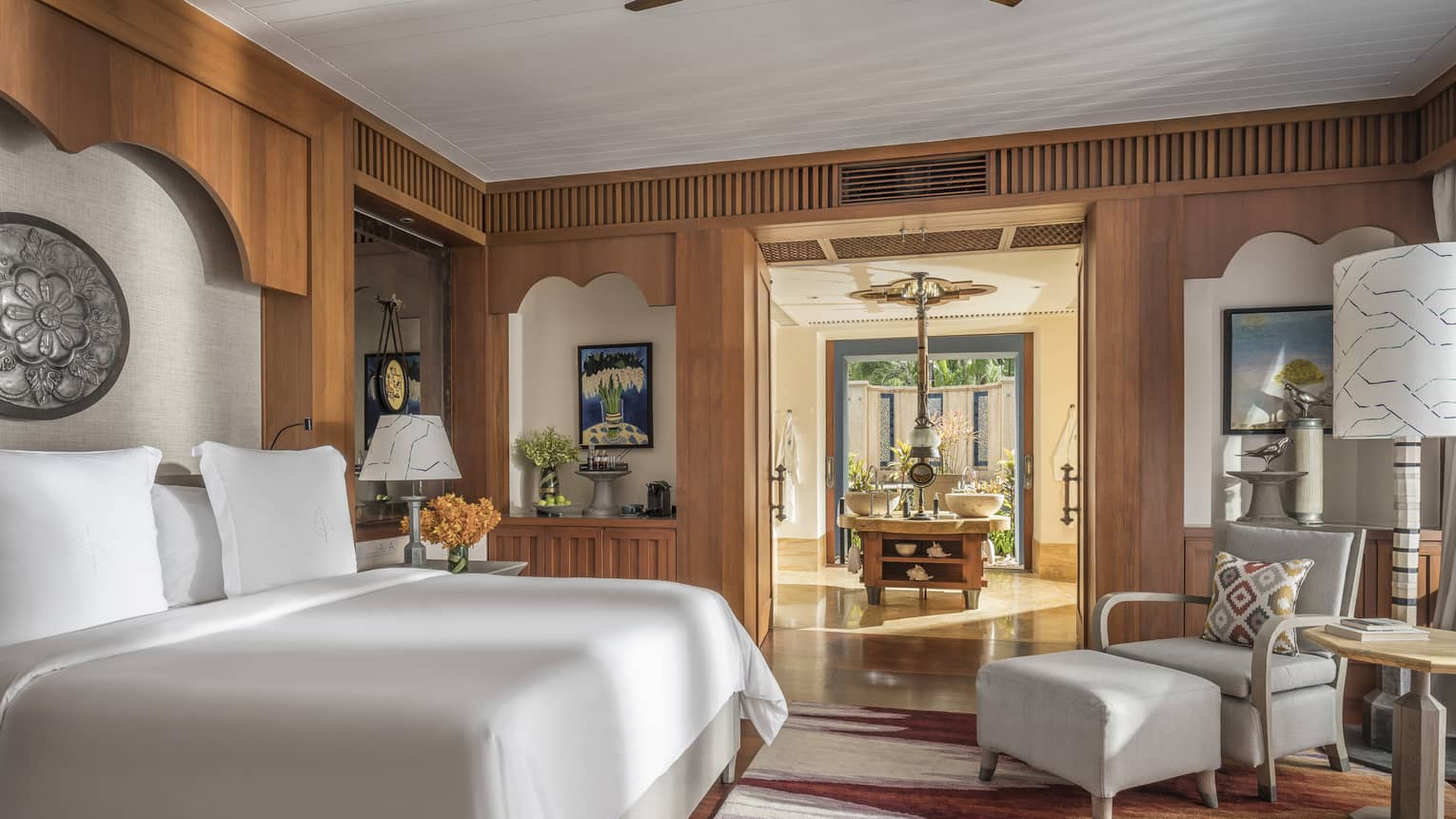 Lower Pavilion Room with white bed and gray club chair