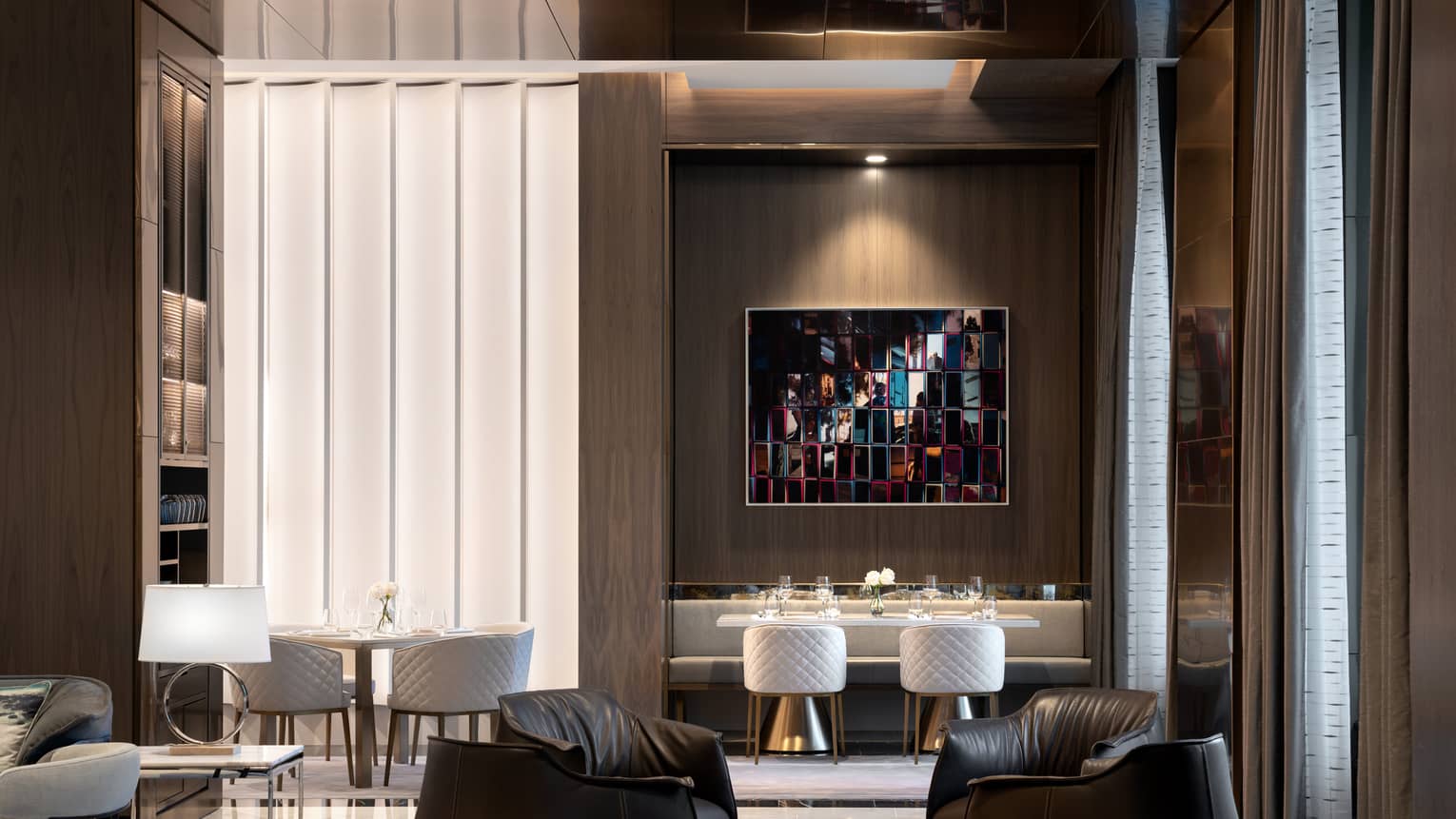 A dimly lit lounge area with leather chairs and tables. 