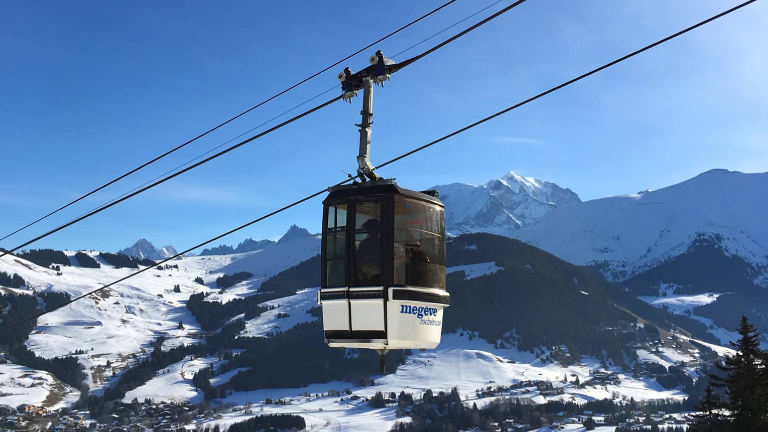 Cable car with snowy French Alps and blue sky in backdrop
