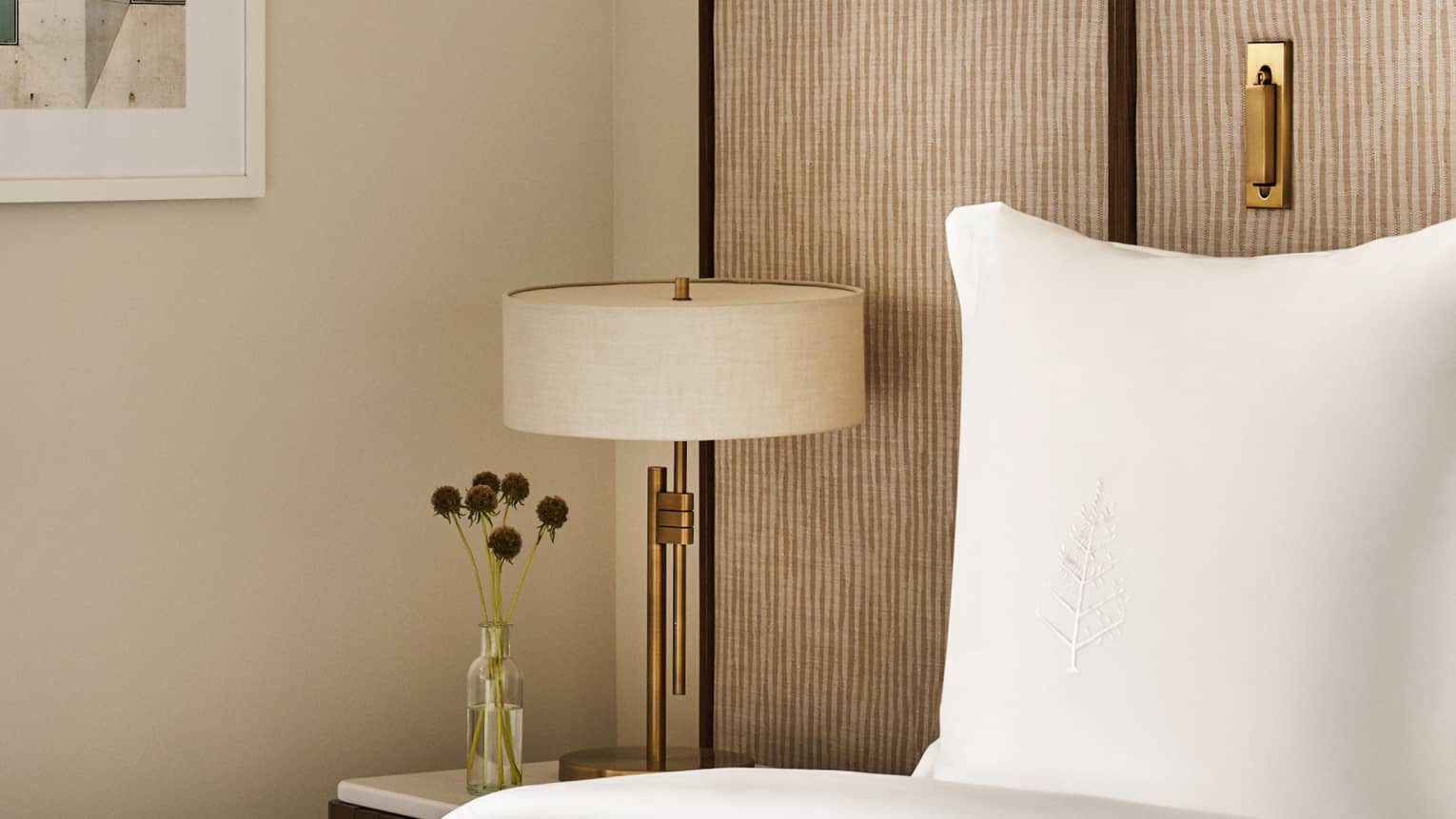 Bed with Four Seasons-embroidered pillow, nightstand with lamp