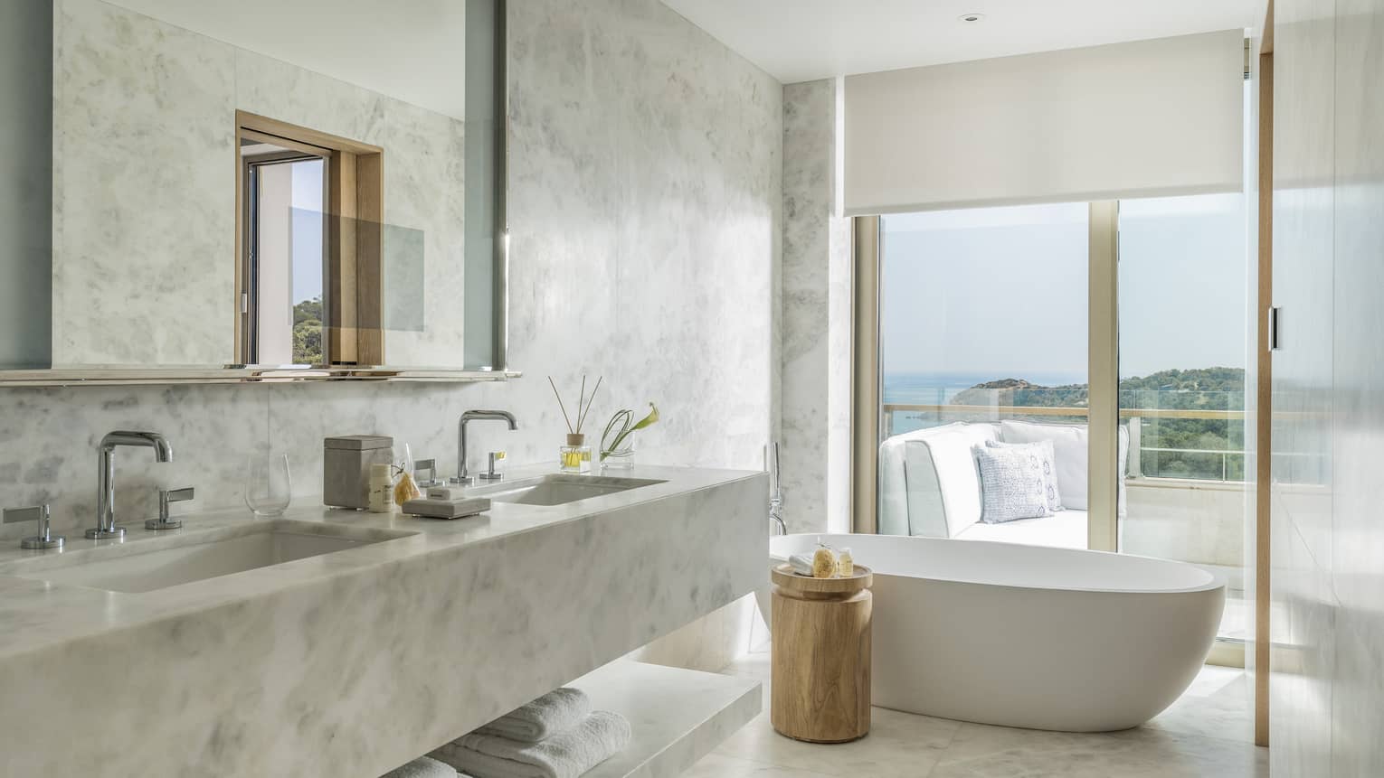 Arion Pine View Bathroom with marbled double vanity, full-width mirror, large soaking tub, ocean views