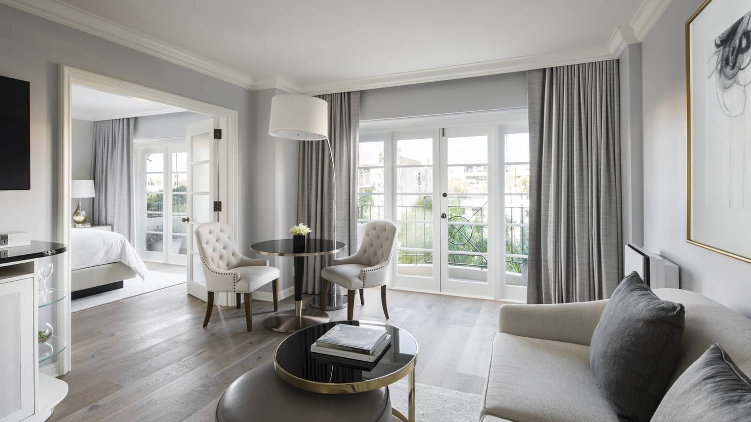 Deluxe Balcony Wellness Room bright living room sofa, table by balcony doors, French doors to bedroom