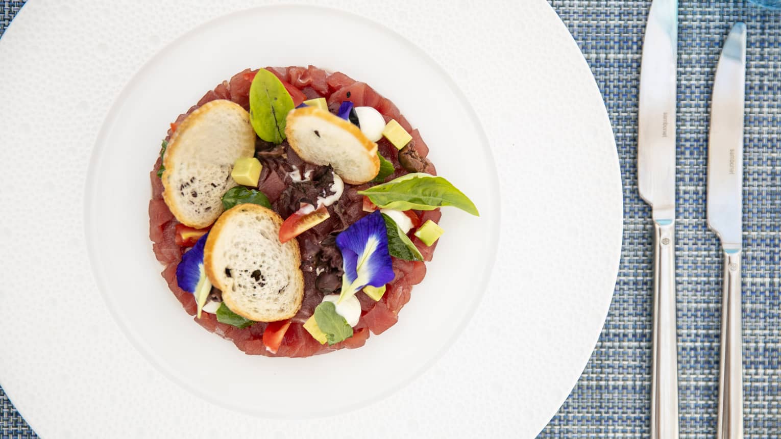 an aerial view of a vegetable dish with small bread rounds 