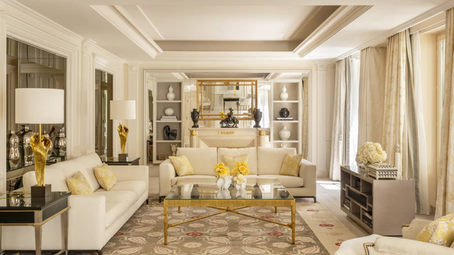 Elegant luxury hotel suite with two off-white sofas, crown molding and built-in shelves