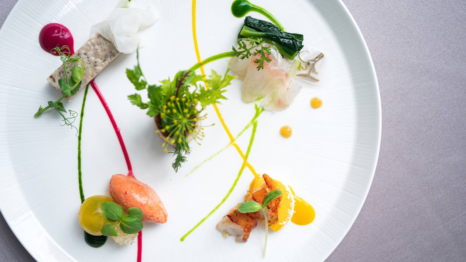 Small appetizers arranged on plate with artistic garnish
