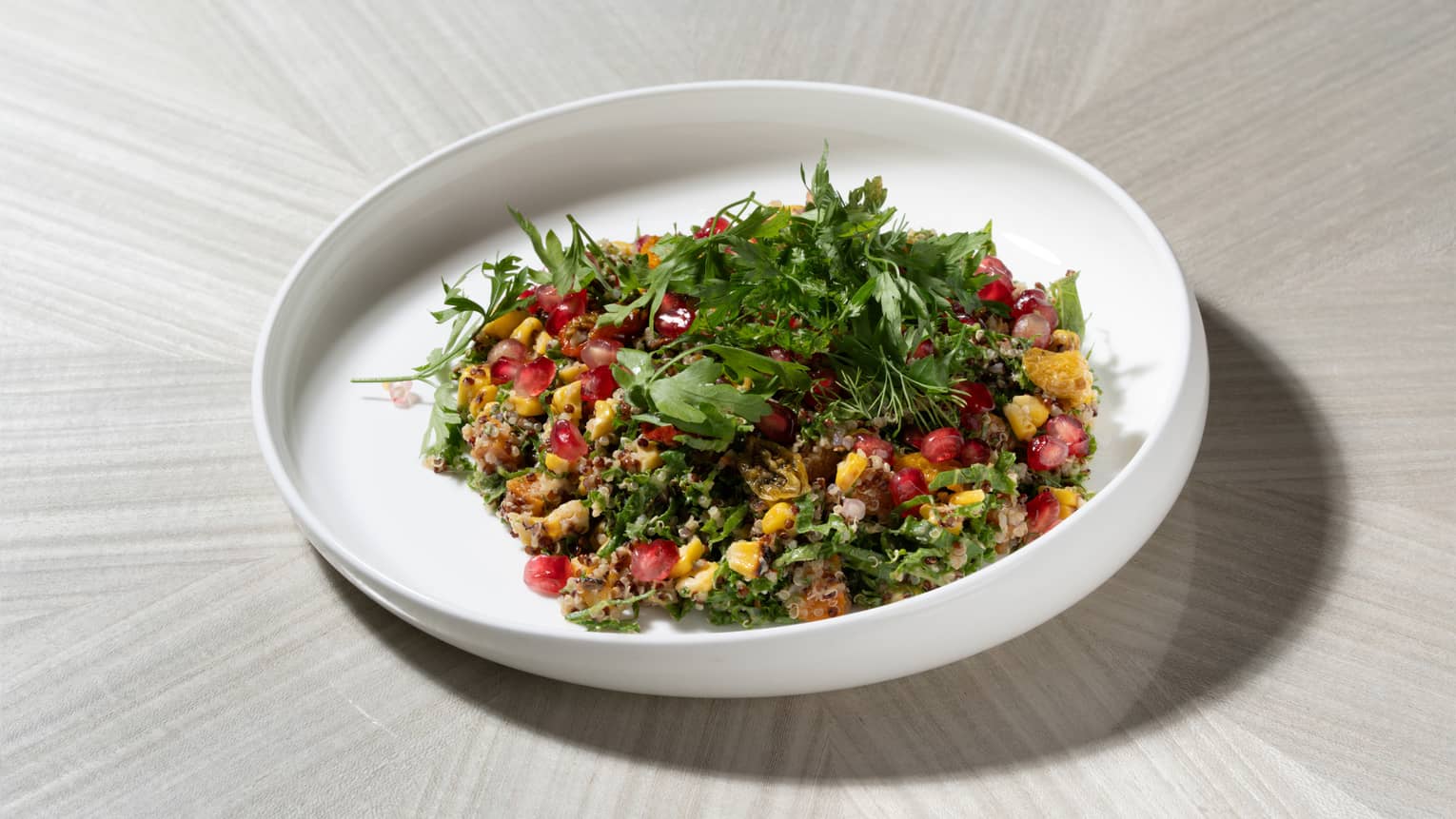 Kale salad served in a round white shallow bowl