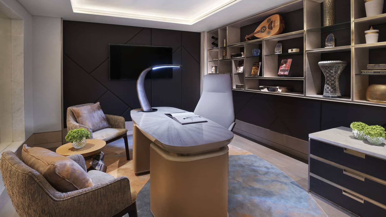 Office with desk, two arm chairs, wall of shelves