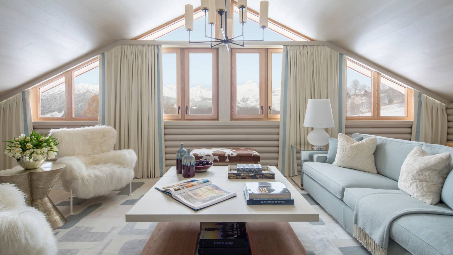 Suite Mont D'Arbois chandelier, windows under gable roof, white sofa, faux fur armchairs