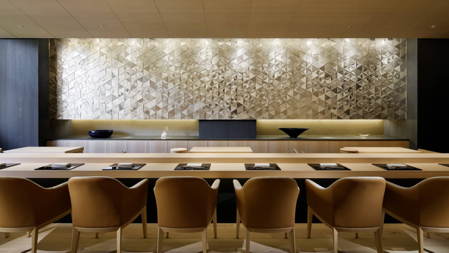 Sushi Wakon large chairs line light wood bar under silver tile wall