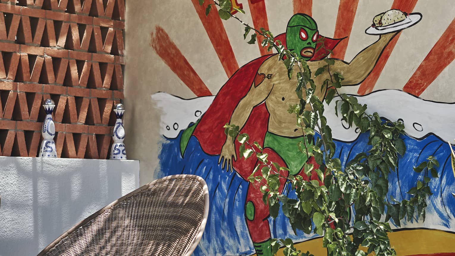 A painting of a green wrestler holding a taco on a plate behind a round chair outside.