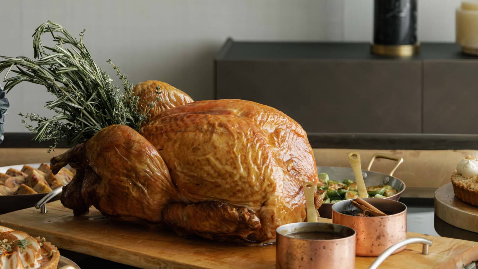A whole roast turkey and sides set out on a dining table