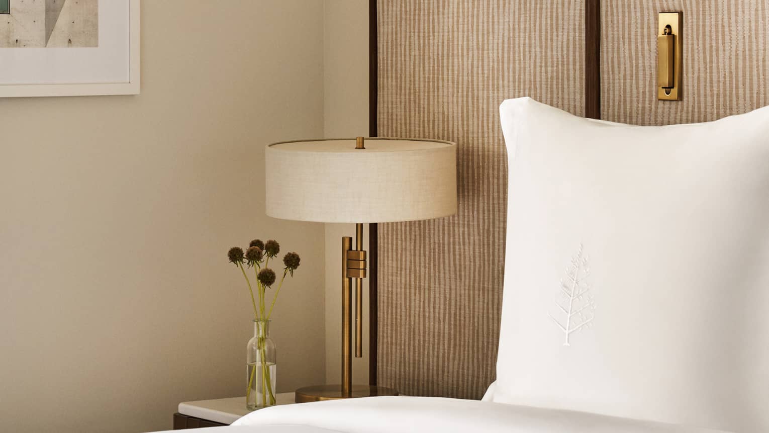 Bed with Four Seasons-embroidered pillow, nightstand with lamp
