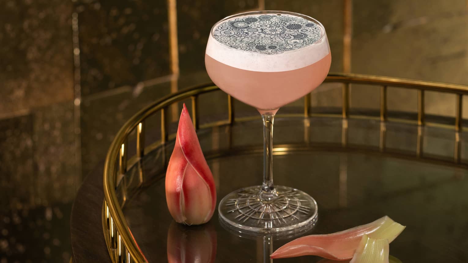 Ribena Haze signature cocktail in stemmed glass on cocktail trolley with pink flower garnishes