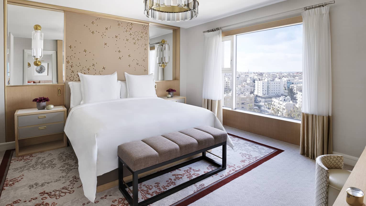 A floral-themed room with a large bed in the centre, and a cityscape view. 