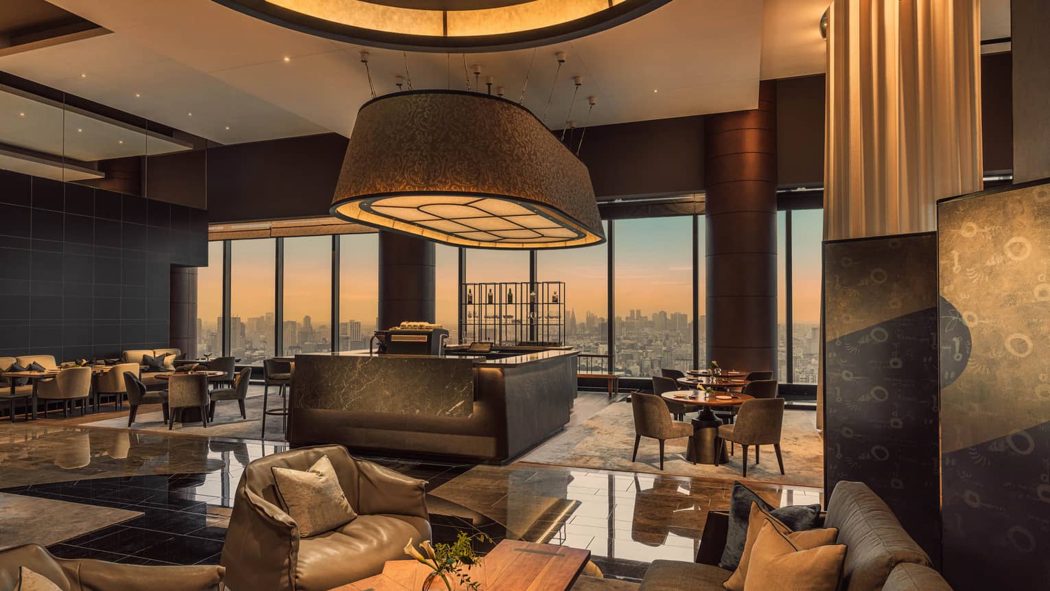 Contemporary hotel lobby lounge with city view at sunset