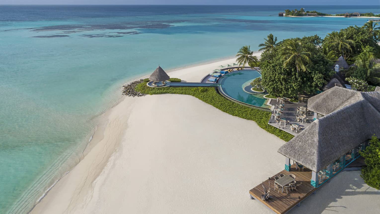 An aerial view of the turquoise water lapping the white sand beach shore near the reef club's terrace 