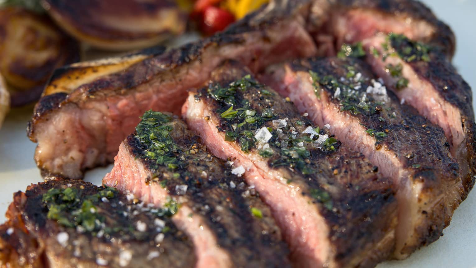 Sliced sirloin steak garnished with capers, Castelvetrano olives and fresh parsley