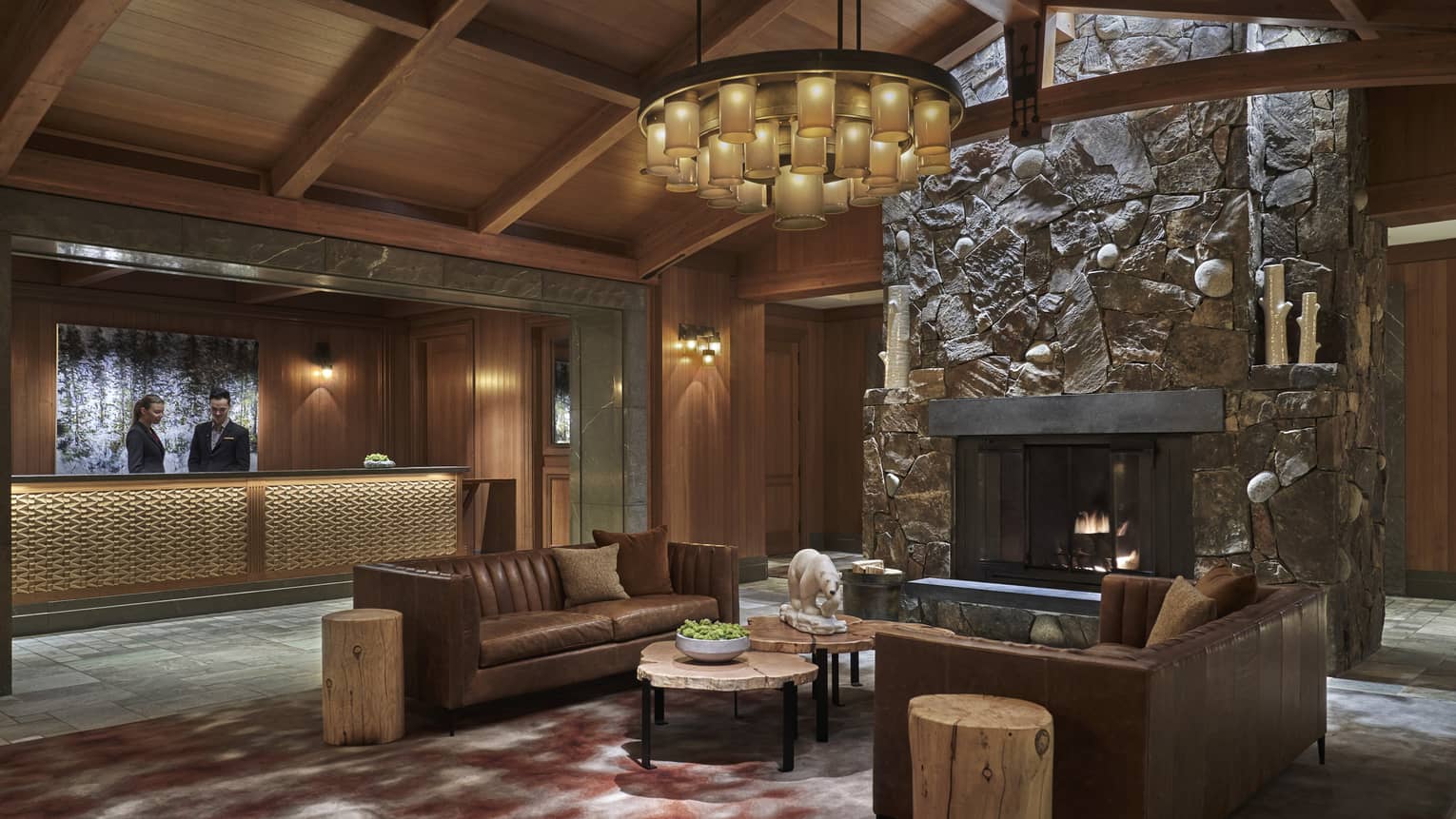 The lobby paneled with dark wood, with a couch in the centre of the room.