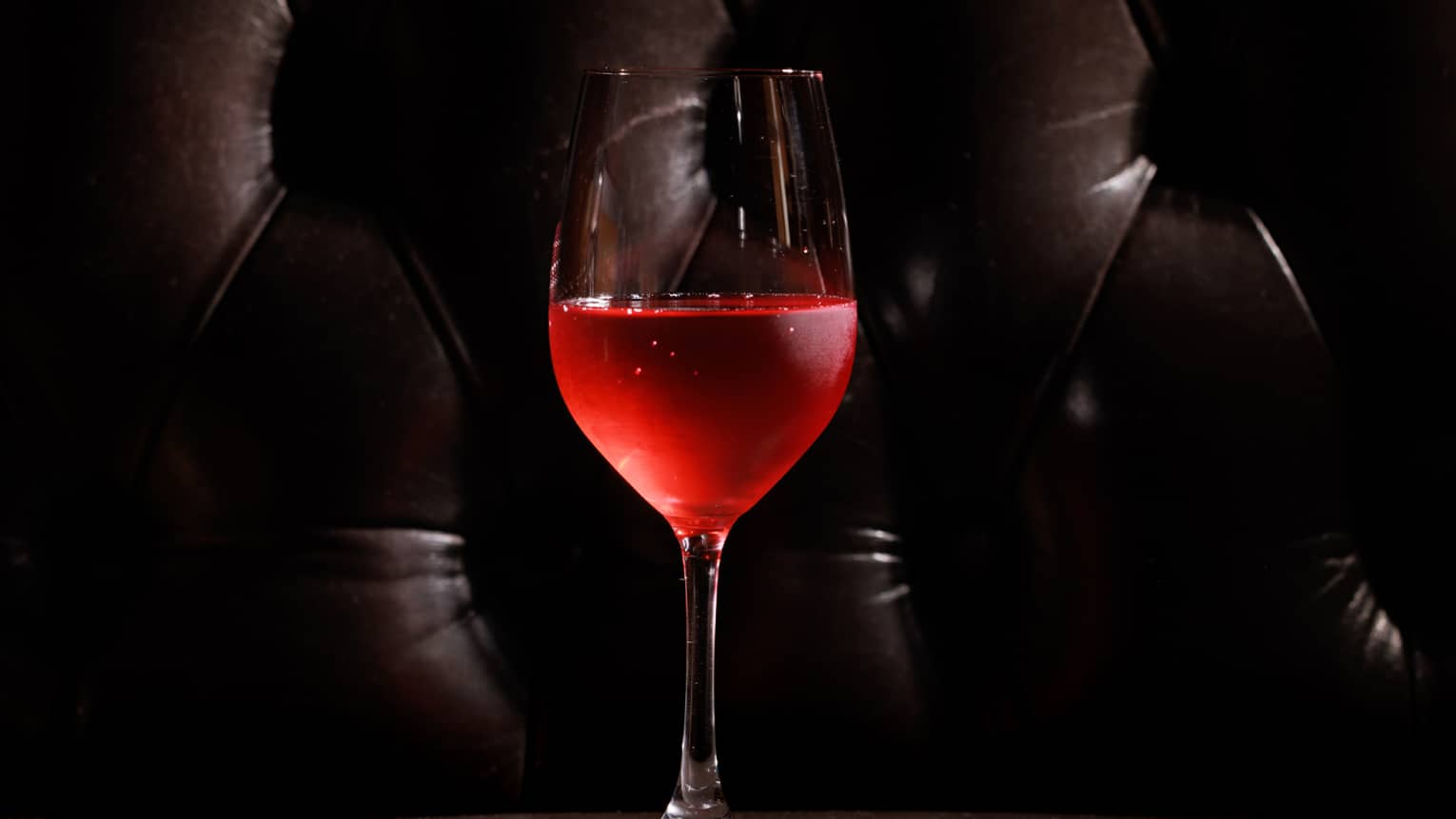 Bright red mocktail served in a tall stemmed glass