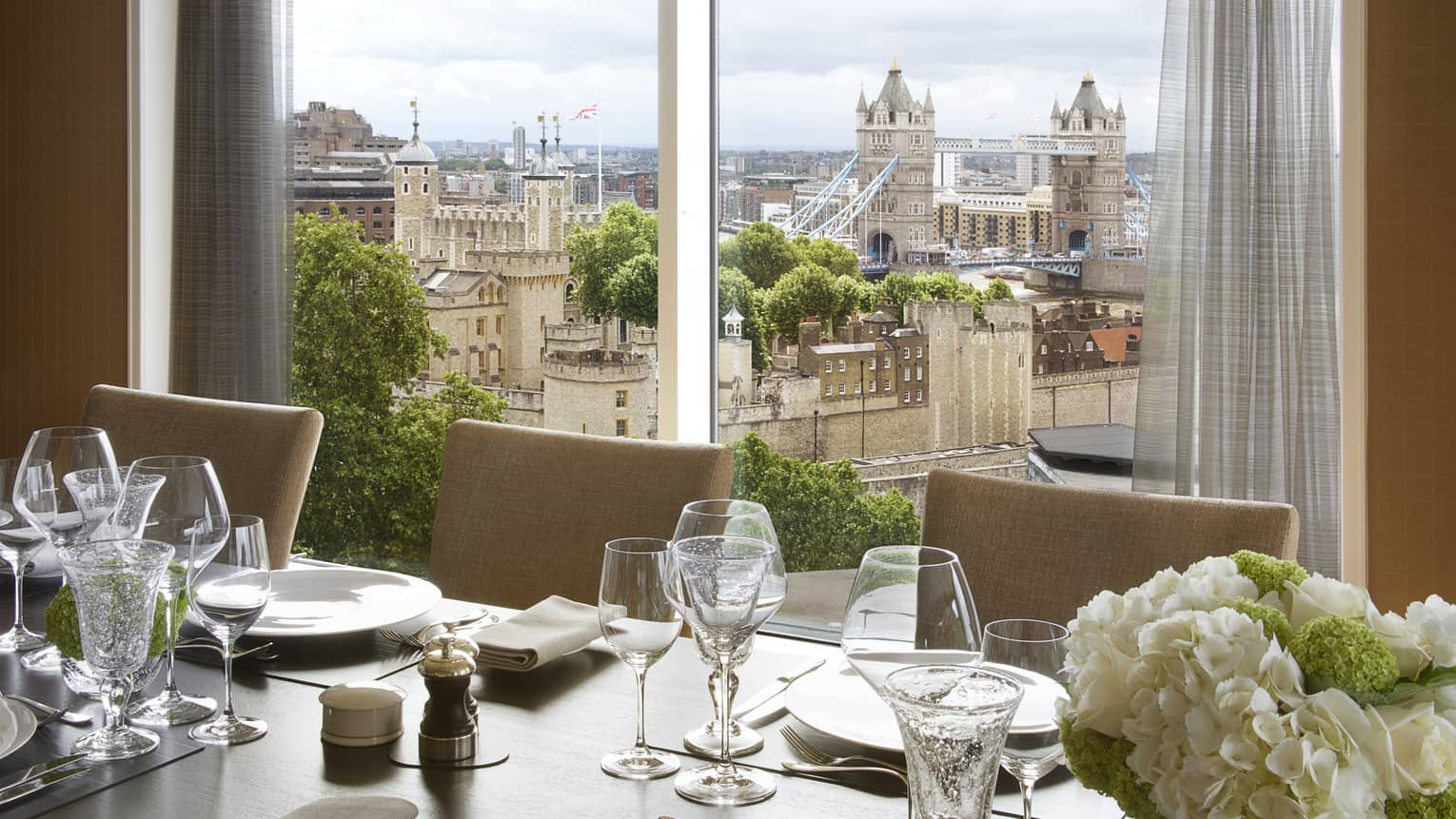 Dining table with white flowers by The Thames Penthouse View window