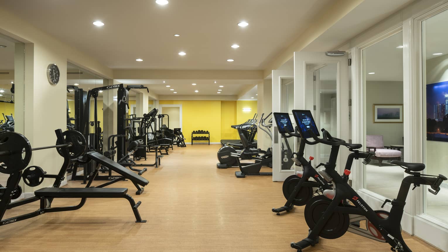 Fitness center room with weight lifting machines and bicycles.