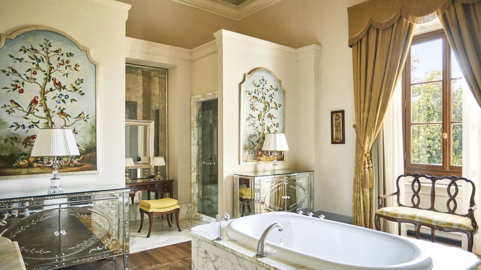 Renaissance Suite bathroom with marble tub set in the middle of the room, window, and makeup vanity, at Four Seasons Hotel Florence