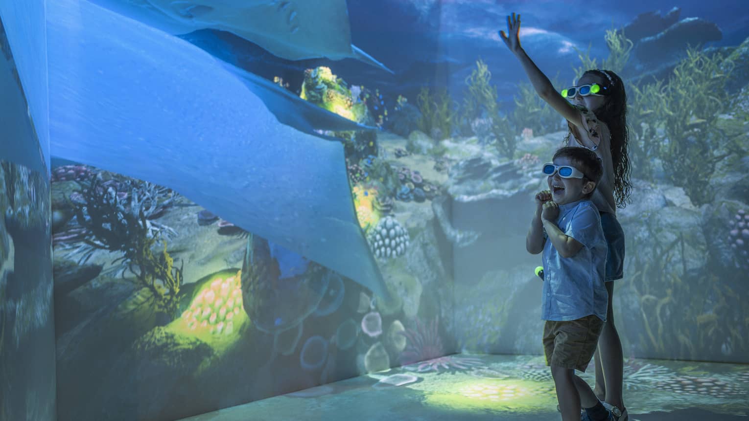 Young girl and boy wearing 3D glasses in the Hologram Room at the Marine Discovery Centre