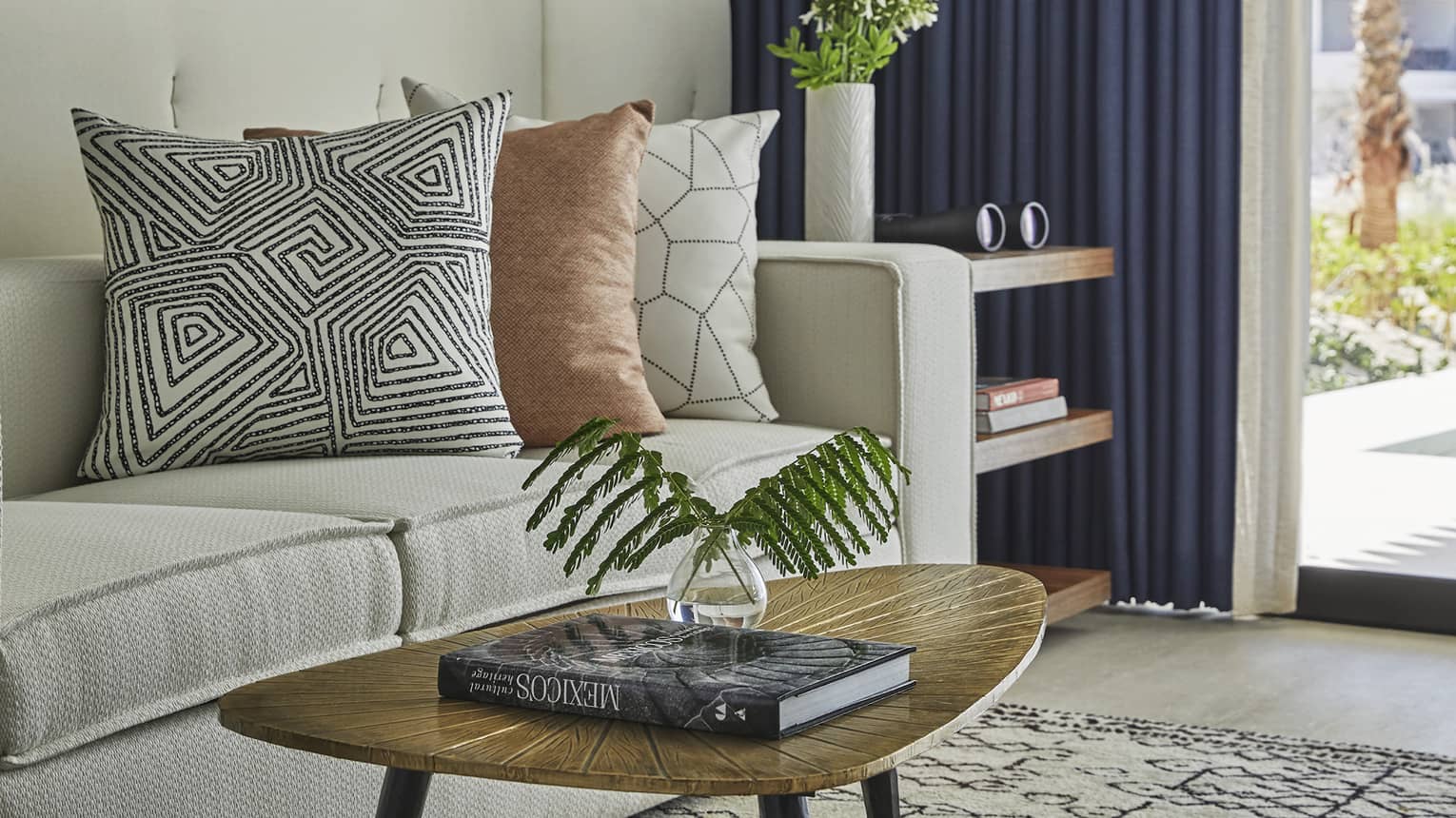 A coffee table with a large coffee book next to a beige sofa.