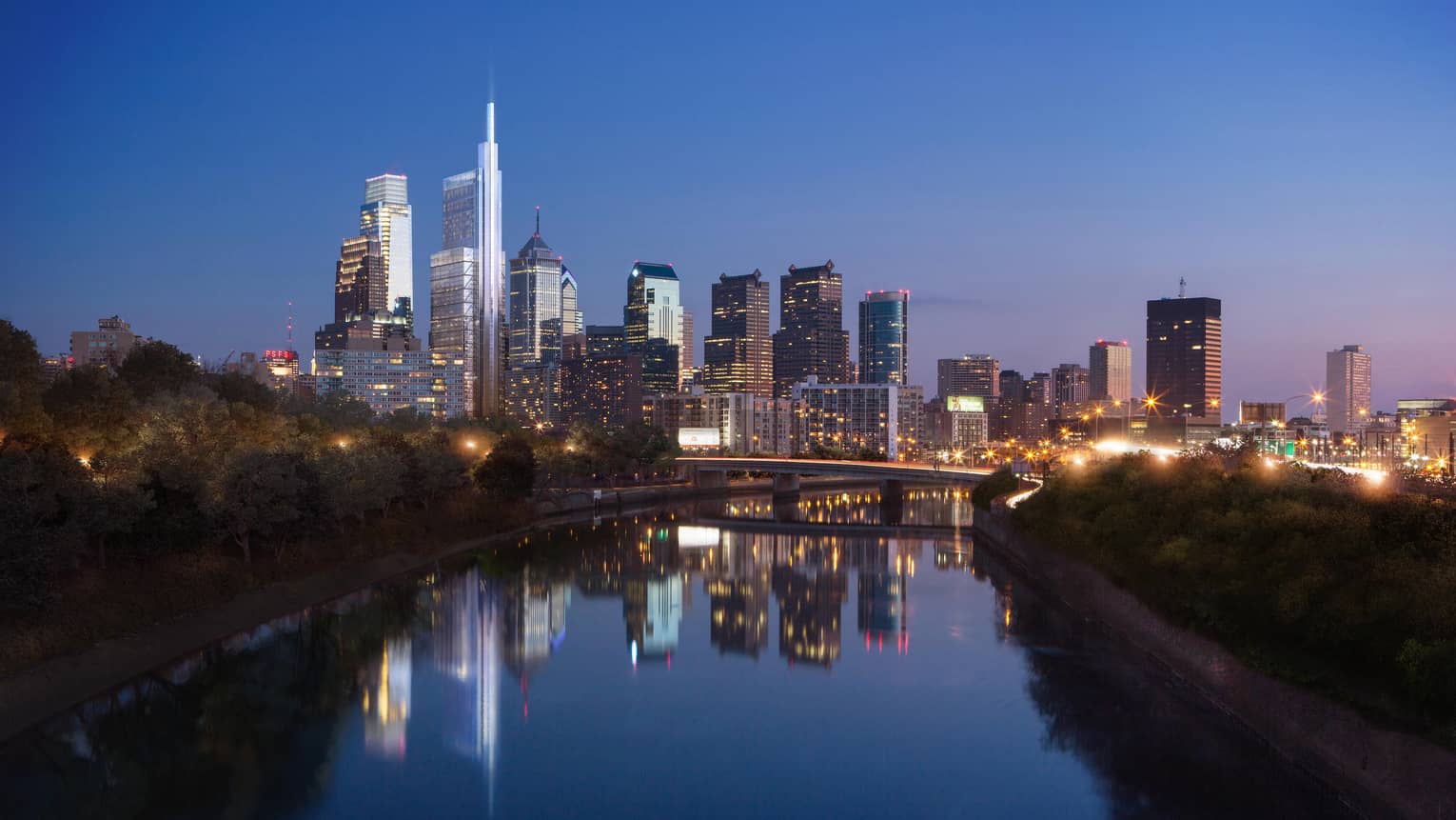 Philadelphia skyline, skyscrapers at dusk with lights reflected on winding river 