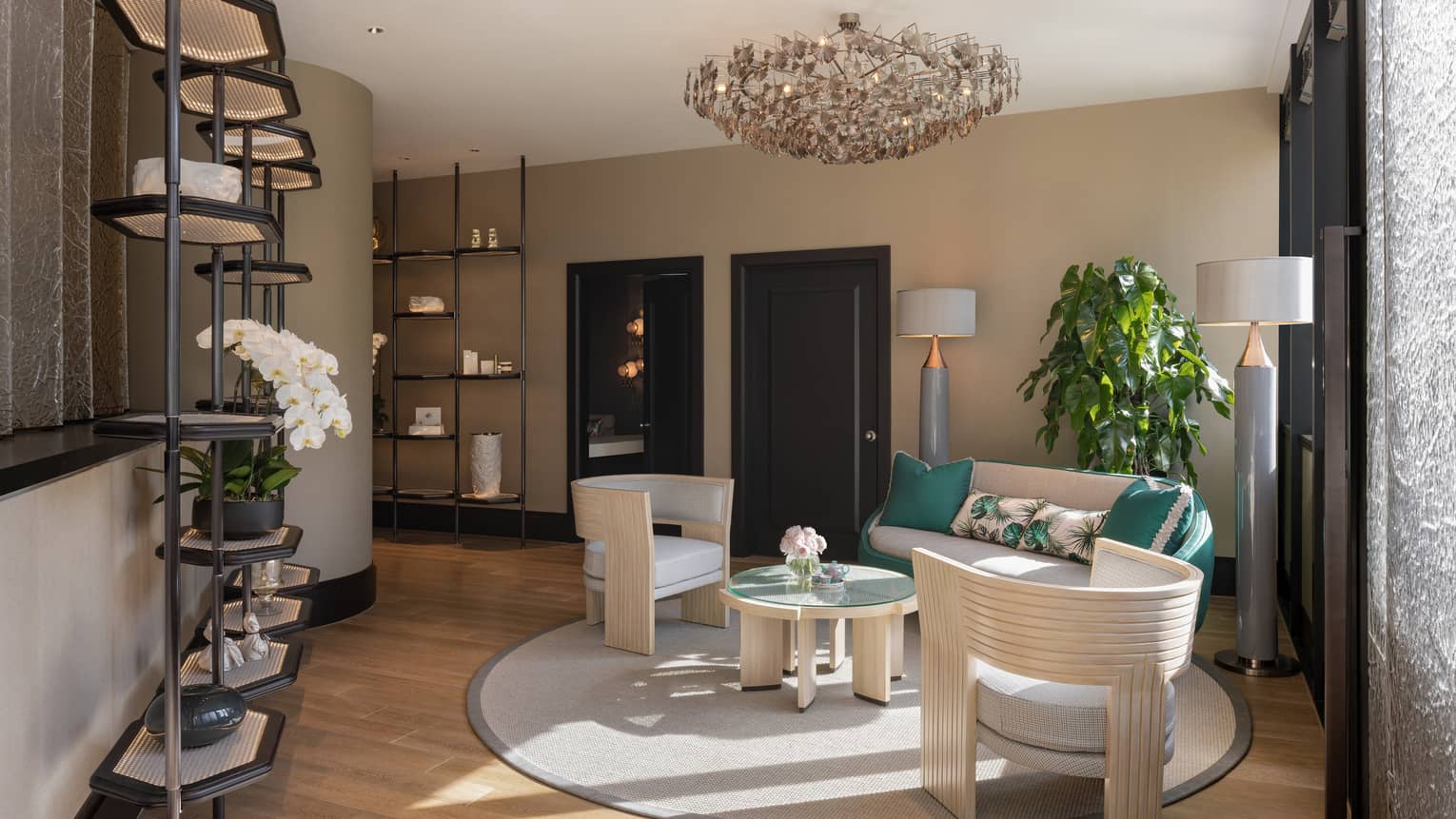Sunlight filters into an empty waiting room with comfortable seating, shelves of delicate display items and white flowers.