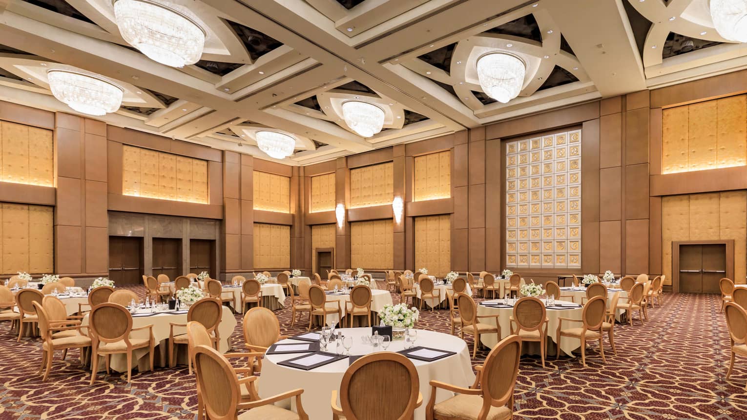 Banquet tables set for an event in a grand hotel ballroom