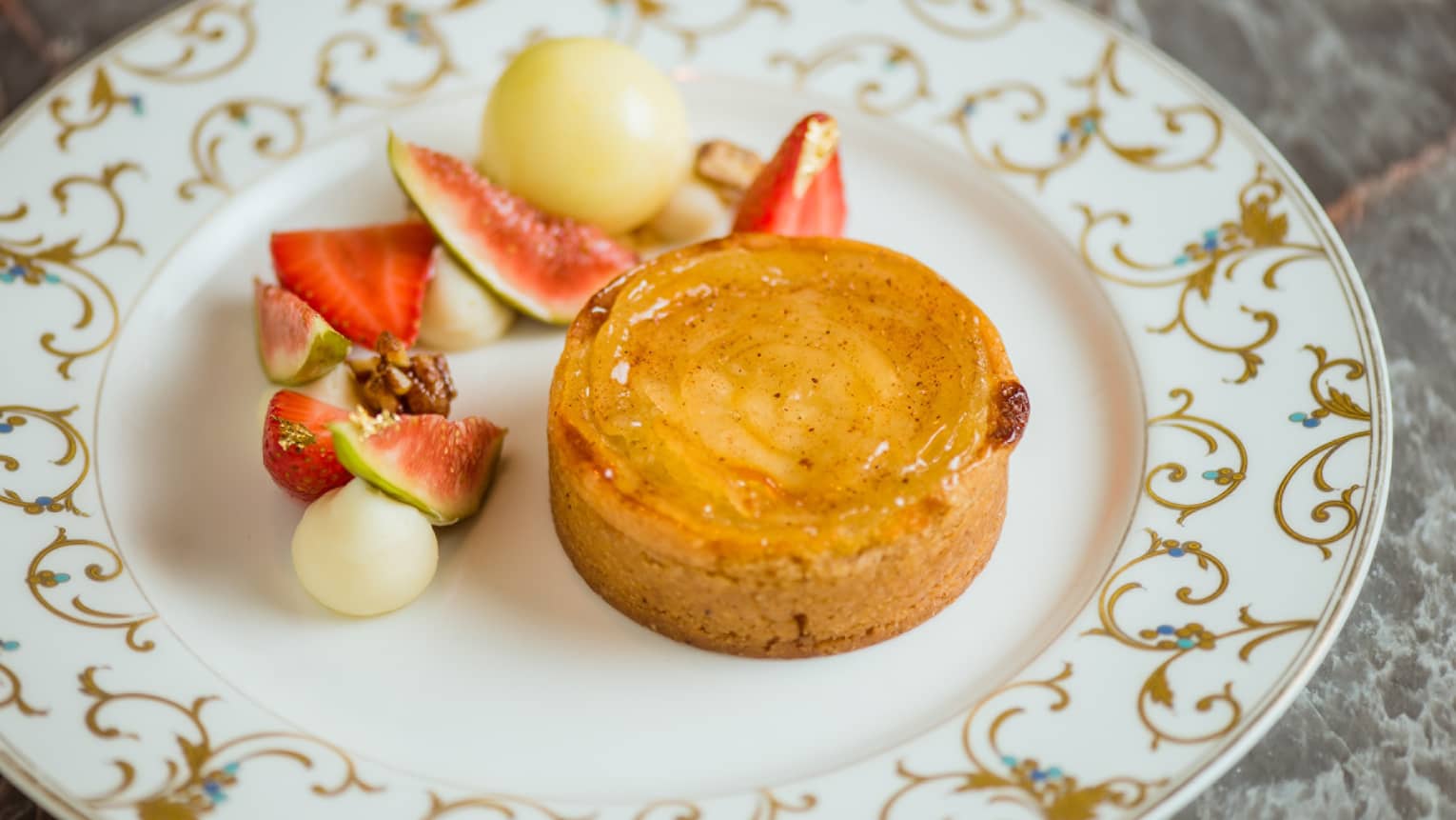 A tart covered with honey, and served with sliced fruit.