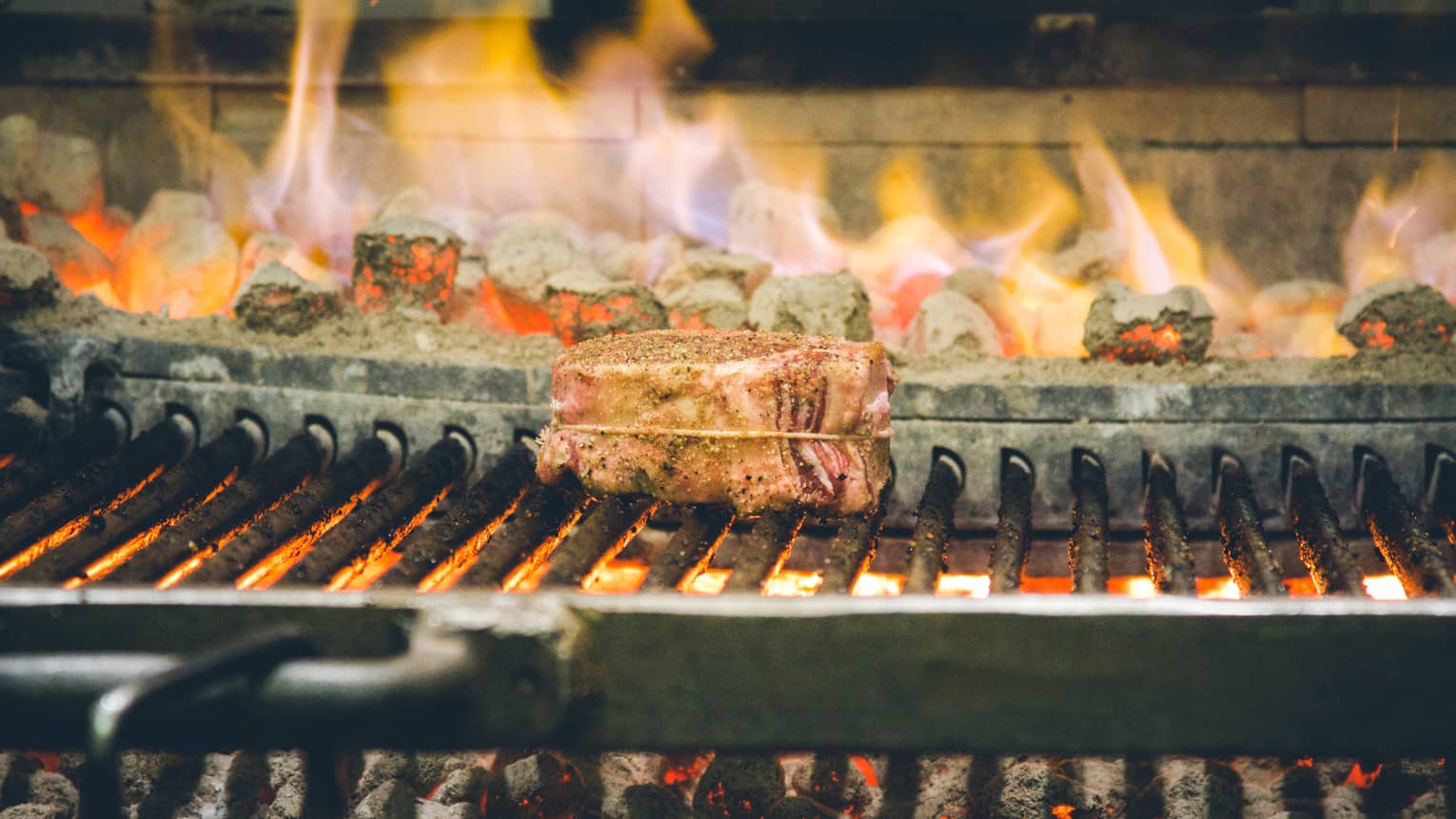 Steak being cooked on an open-flame grill