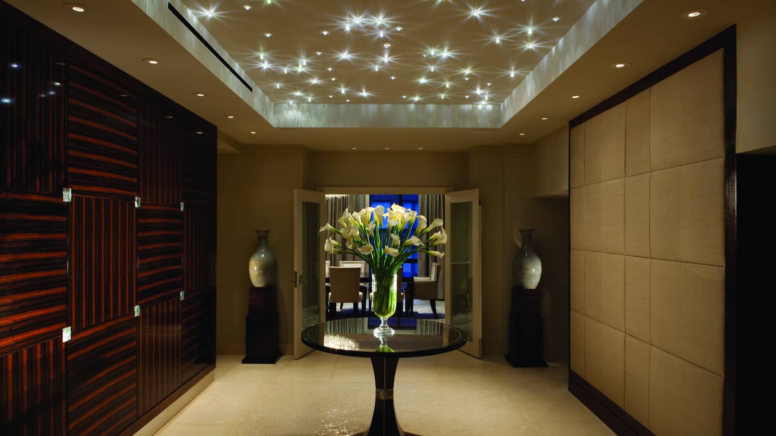 Royal Suite art deco-style private hallway under sparkling lights, door to private dining room at night