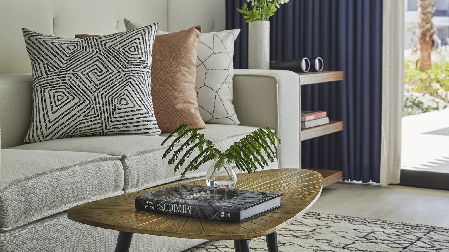 A coffee table with a large coffee book next to a beige sofa.