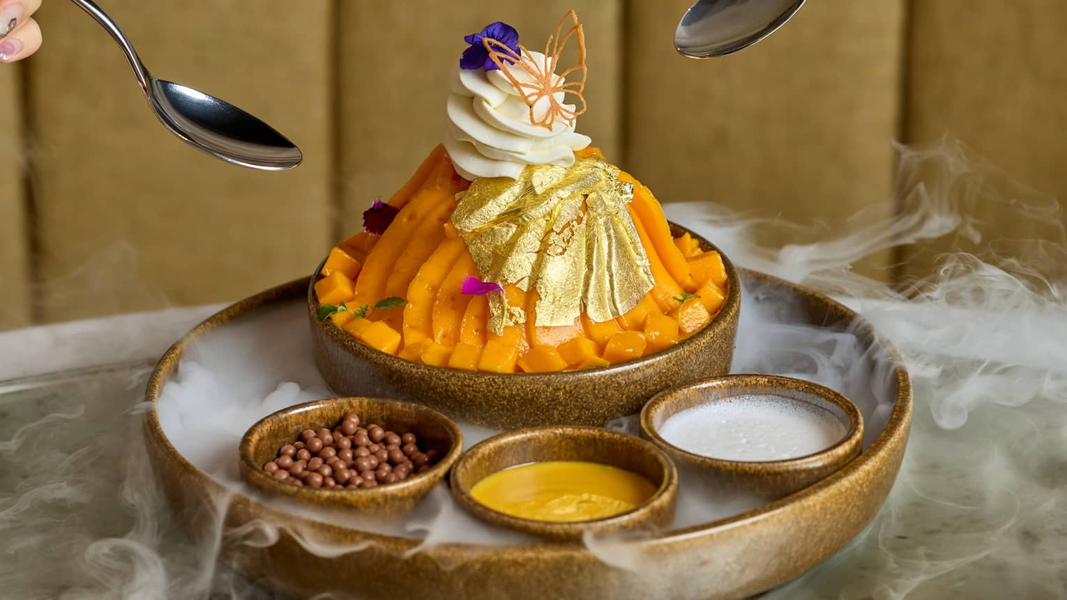Bright orange dessert topped with cream and served with three small bowls of garnish
