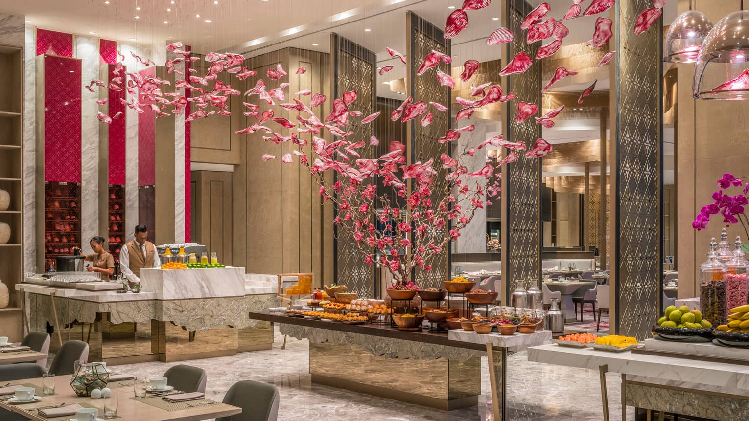 Curate buffet table with fruits and vegetables and servers arranging food