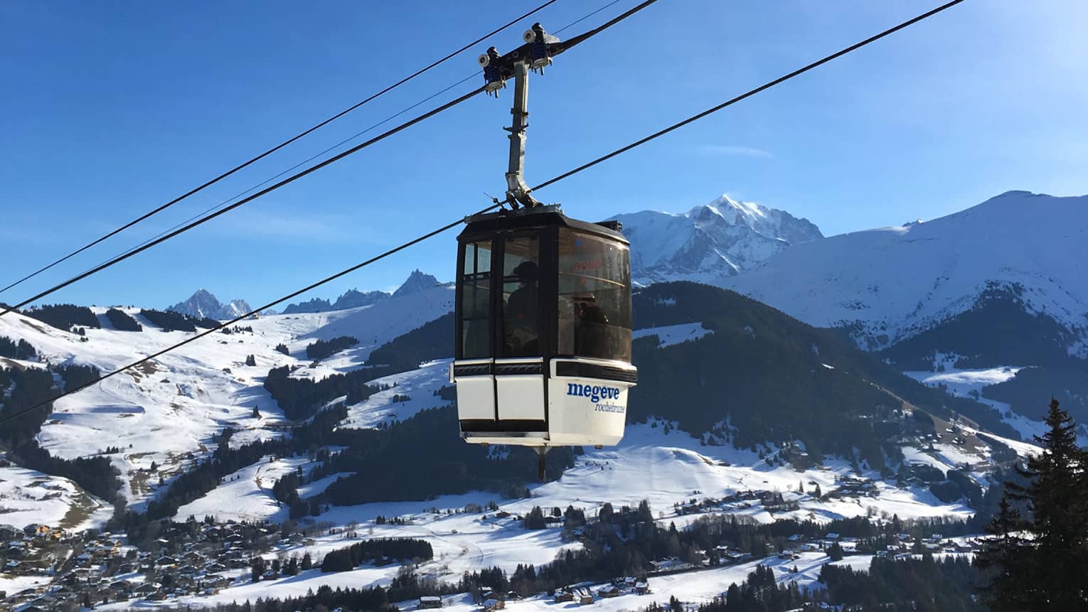 Cable car with snowy French Alps and blue sky in backdrop