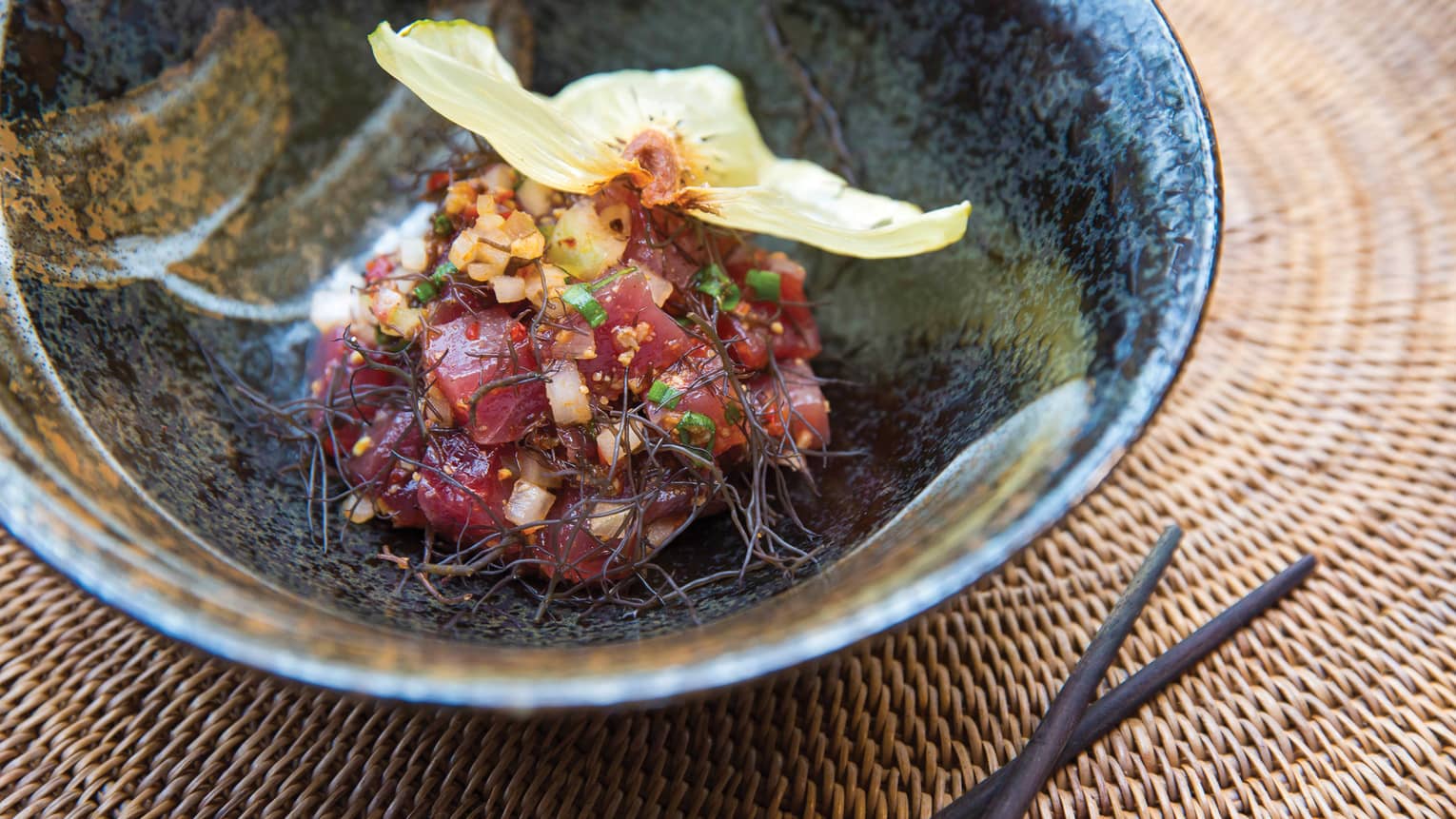 Hawaiian ‘Ahi Poke bowl with raw tuna, ogo, shoyu, minced vegetables, flower