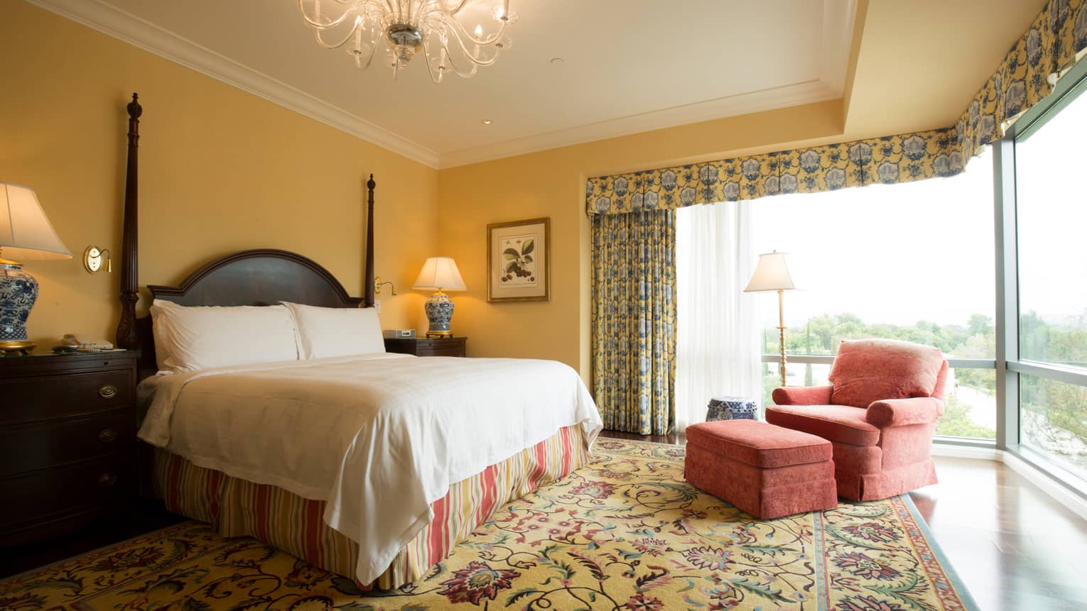Malibu Corner One-bedroom Suite poster bed with striped skirt under chandelier