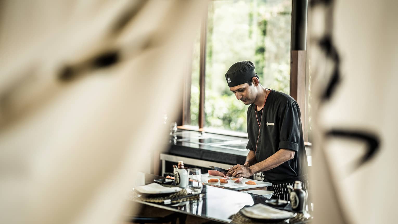 KOI chef prepares sushi at counter in brightly lit room