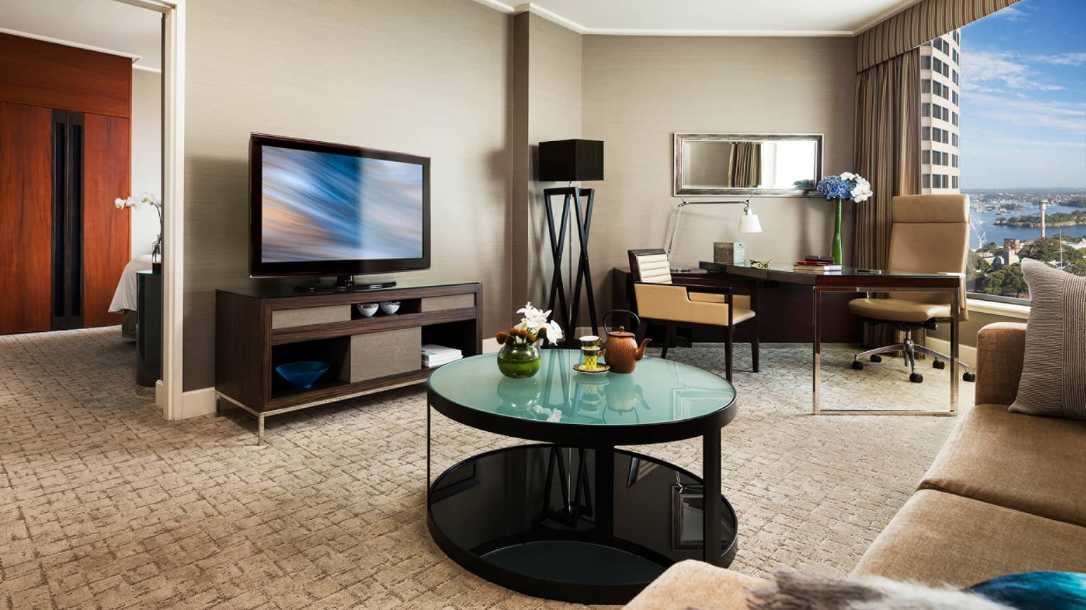 Club Harbour Partial Suite round green glass table with teapot, flowers by TV, desk