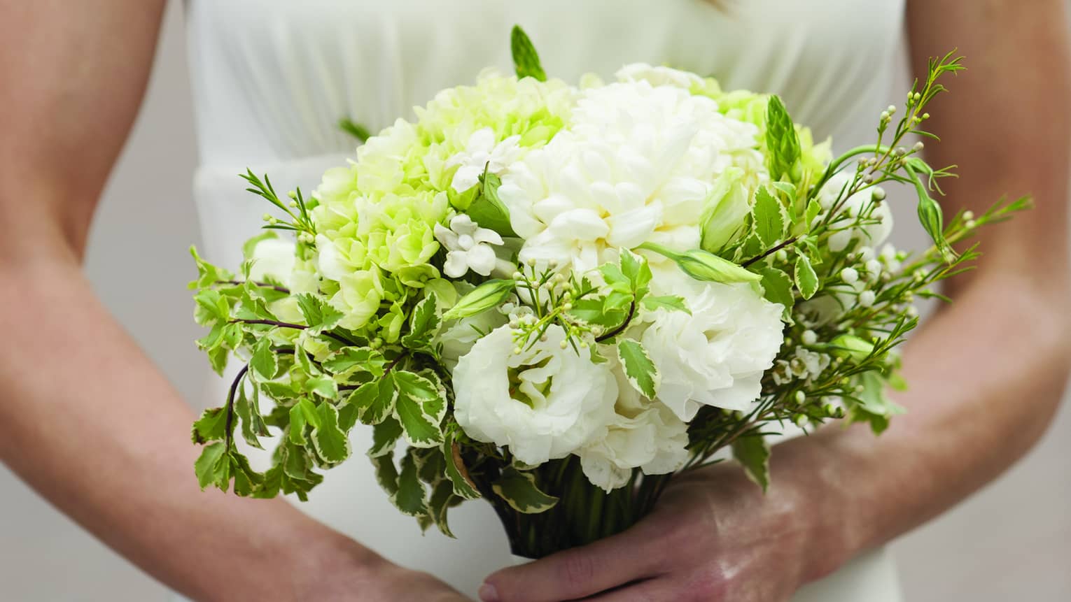 Bride holding white floral wedding bouquet 