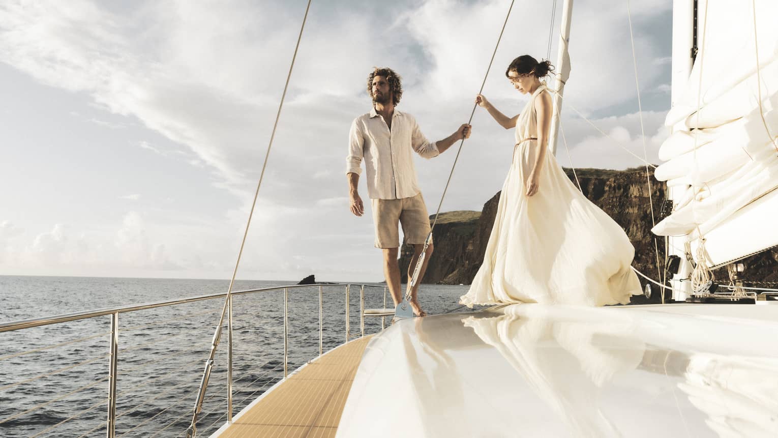 Man and woman stand on deck of catamaran while at sea in Lanai