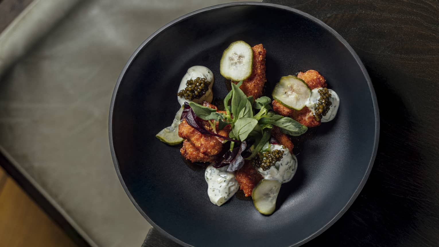 Plate of fried chicken with green garnishes