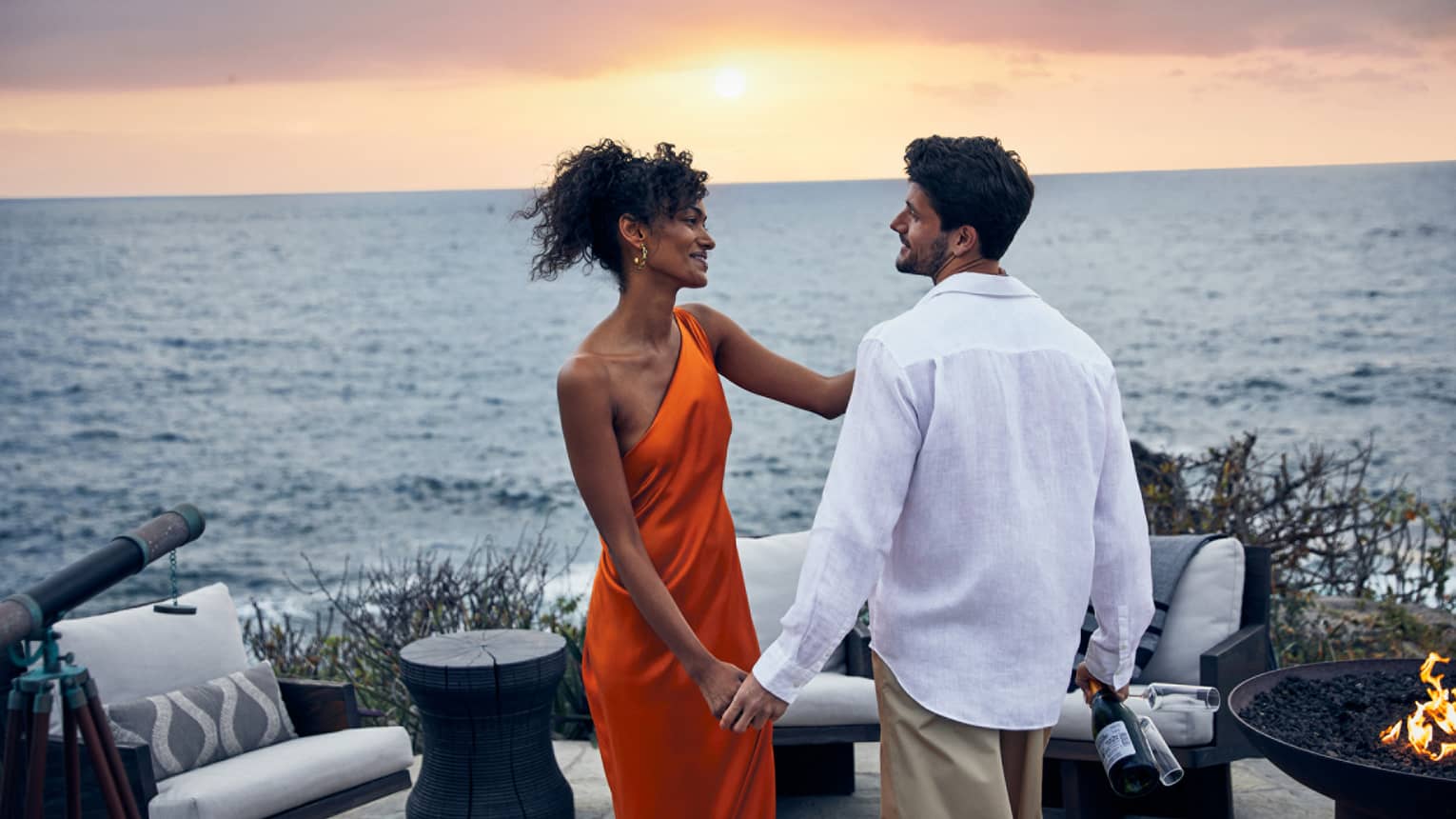 A couple sharing a romantic sunset view over the ocean.