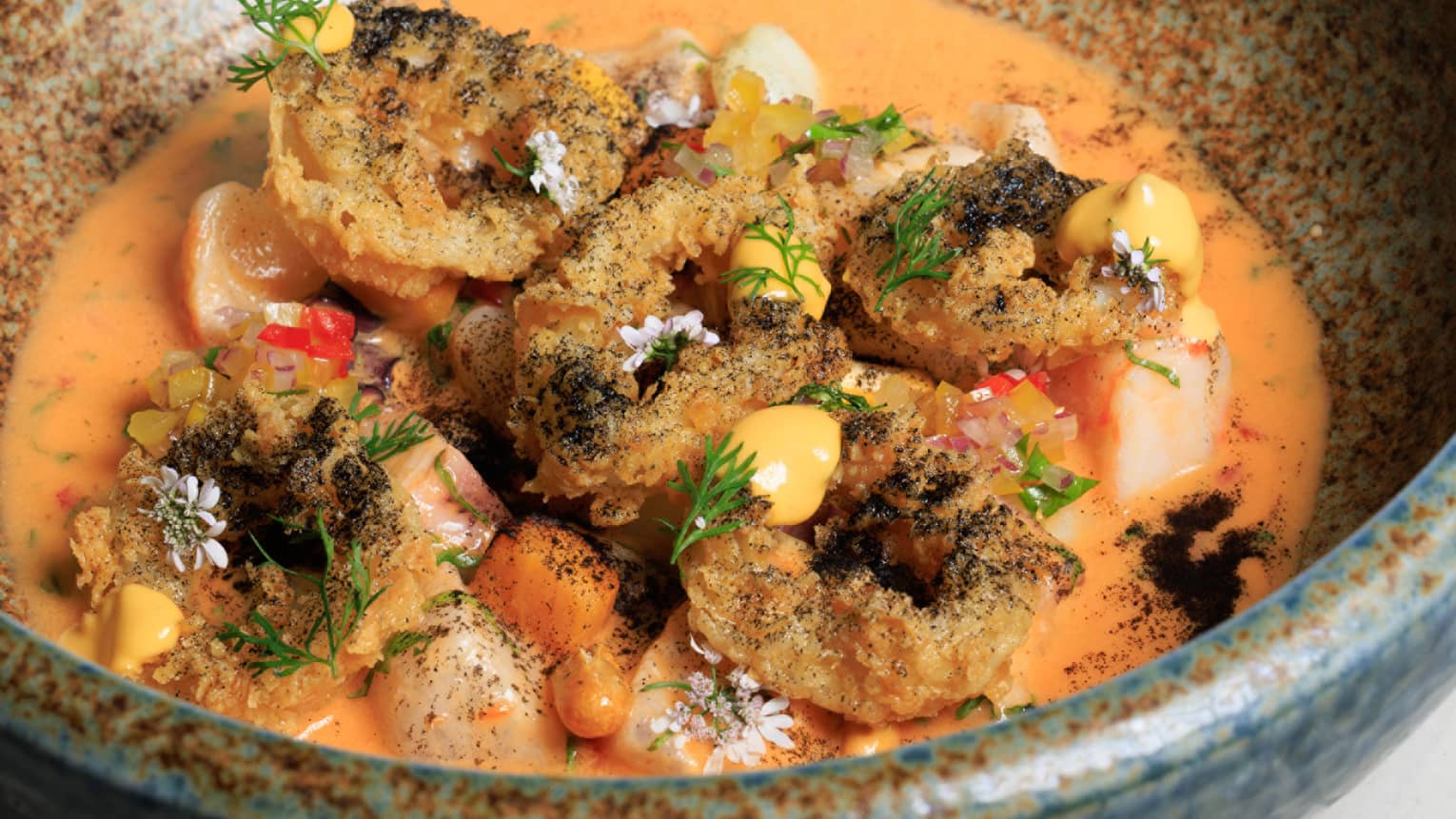 Ceviche with scallops, octopus, shrimp, crispy calamari and rocoto ?leche de tigre? served in a stoneware bowl